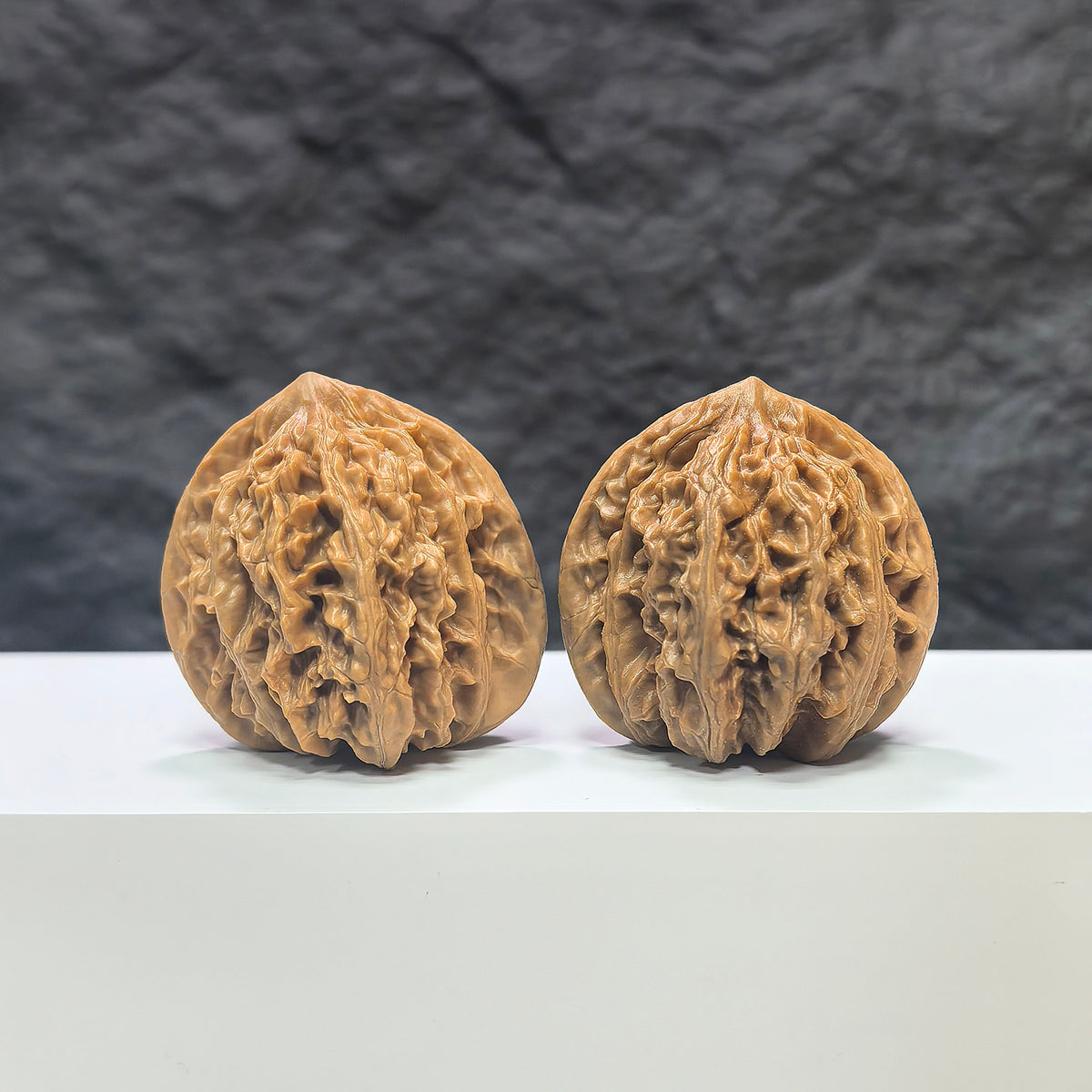 Pair of Peach Heart Xiayunling Wenwan walnuts from Wenwan Art, featuring smooth, polished walnut surfaces with intricate natural patterns.