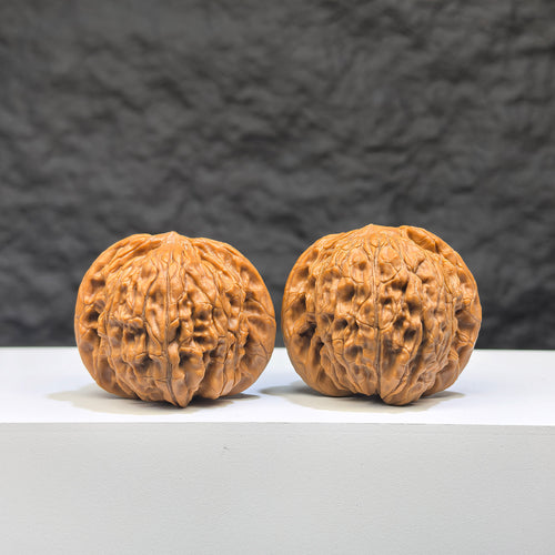 Pair of Wenwan Art Millstone Classic Wenwan walnuts, 38mm x 34mm, with detailed carvings and smooth polished surfaces.