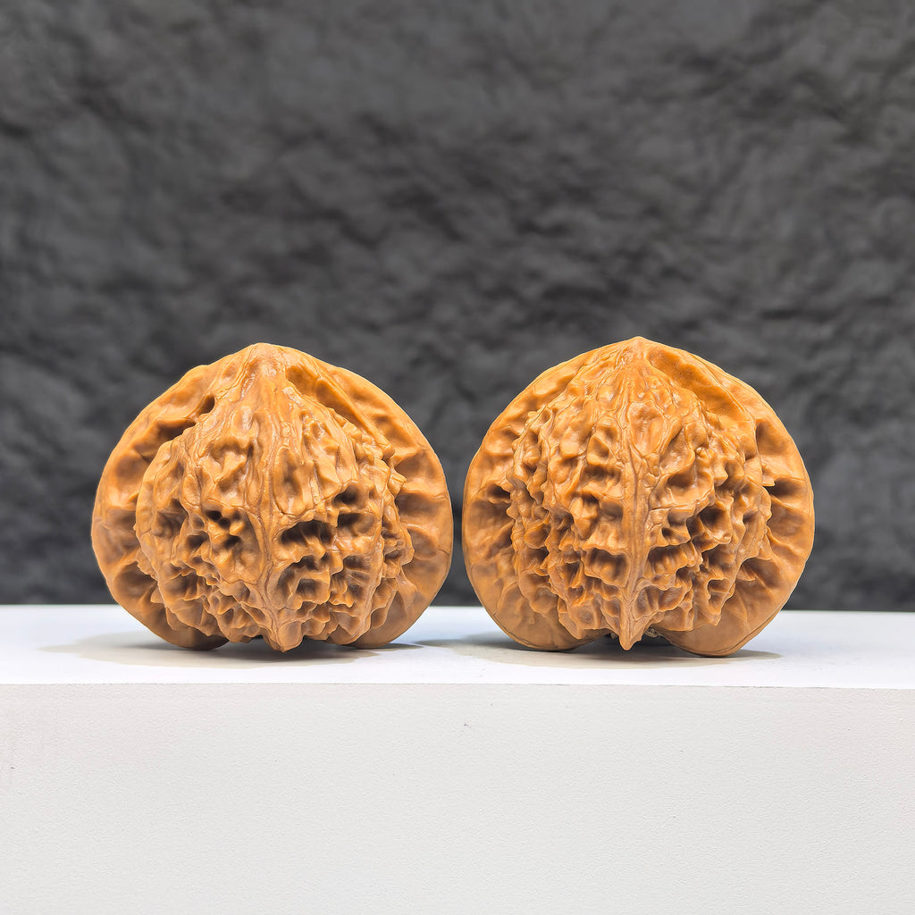 Pair of Peach Heart Palace Lantern Wenwan walnuts by Wenwan Art, featuring carved peach heart designs and smooth polished surfaces.
