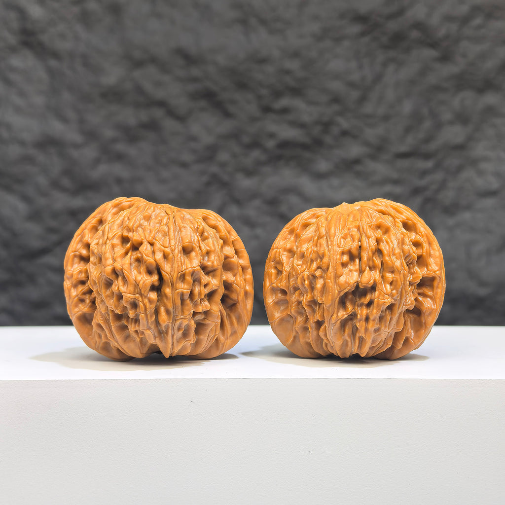 Pair of Wenwan Art Millstone Classic Wenwan walnuts, 37mm x 35mm, showcasing detailed carvings and smooth polished surfaces.