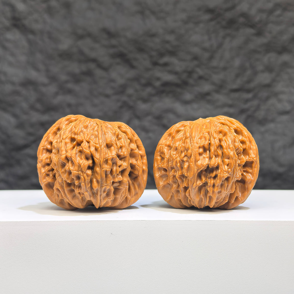Pair of Wenwan Art Millstone Classic Wenwan walnuts, 37mm x 35mm, showcasing detailed carvings and smooth polished surfaces.