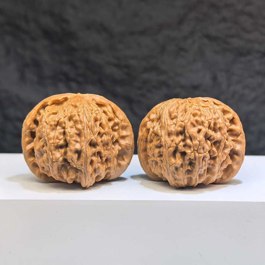 Pair of White Lion Wenwan Walnuts by Wenwan Art, featuring detailed carvings and natural white coloration, measuring 42mm by 41mm.