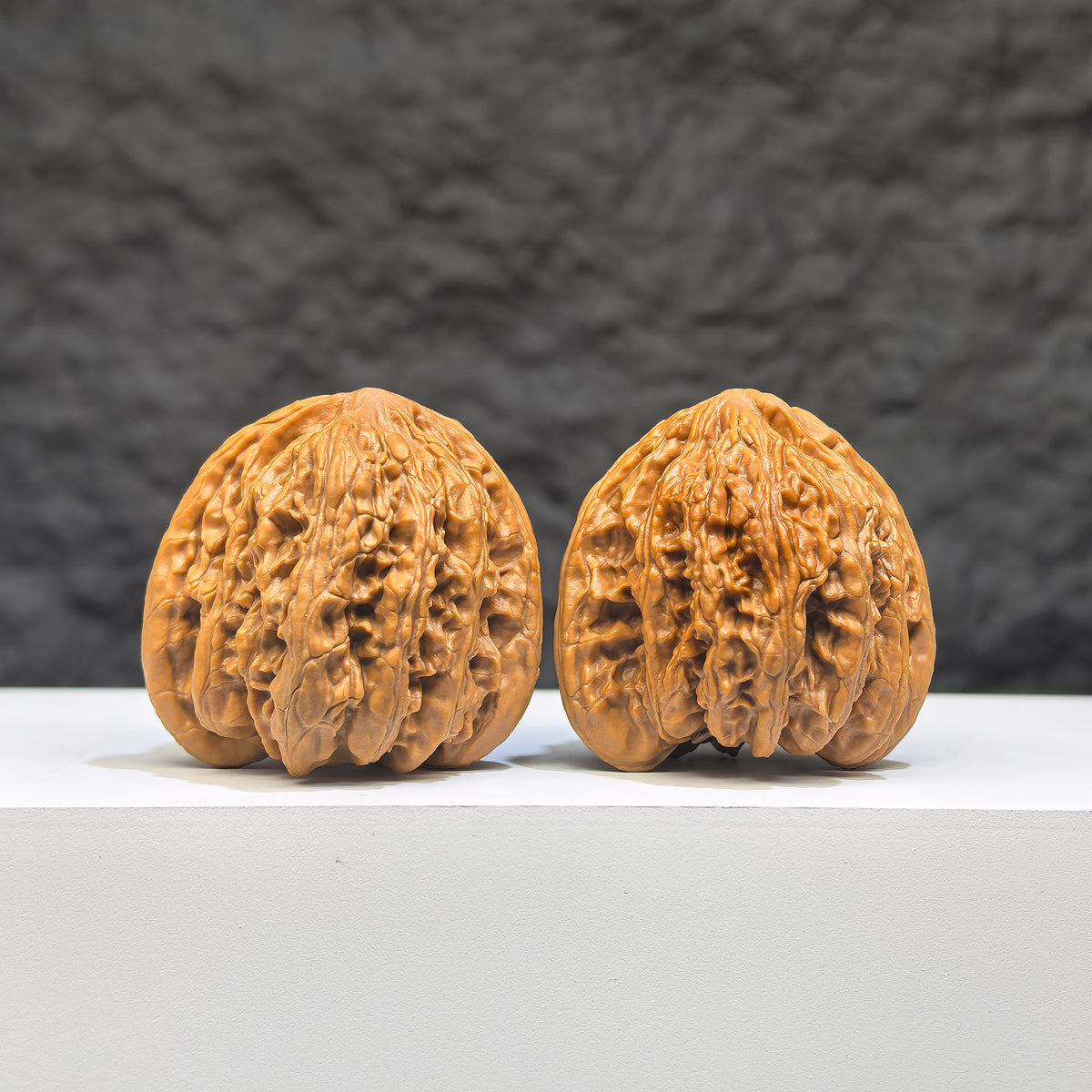 Pair of Peach Heart Concave Base Wenwan Walnuts by Wenwan Art, deep-base ruby-colored walnuts, 35mm x 33mm, with intricate natural details.