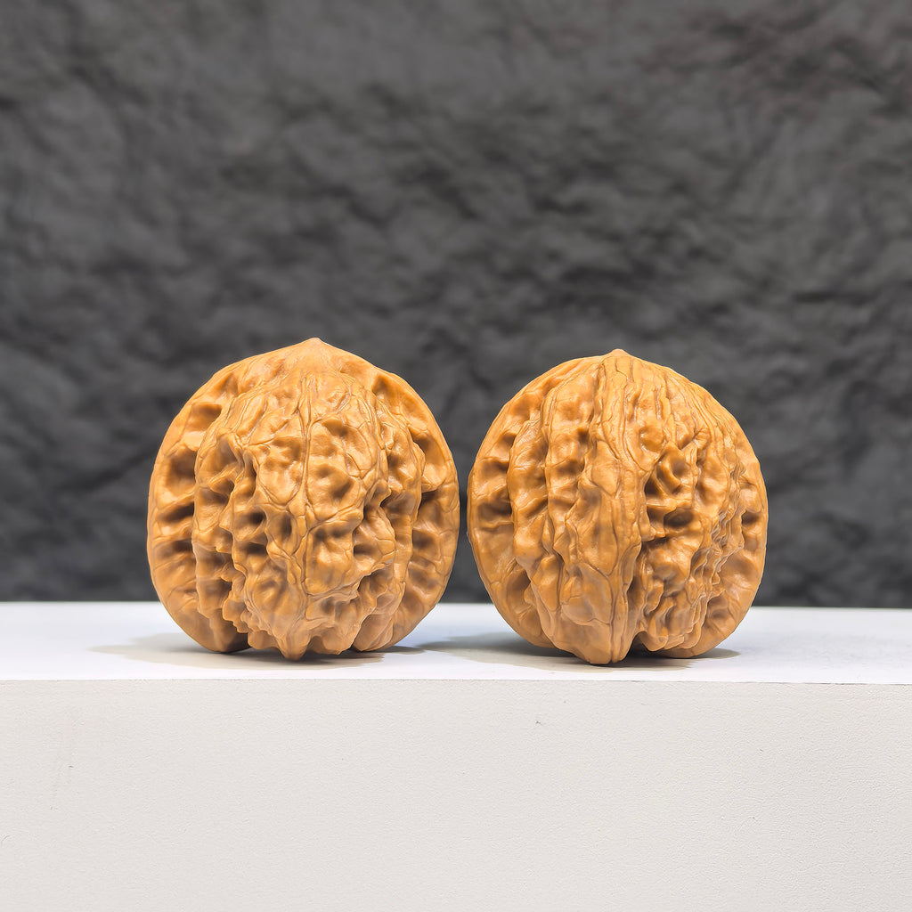 Pair of authentic Wenwan Wild Wolf walnuts by Wenwan Art, 35mm x 37mm, featuring natural wild wolf carvings on smooth walnut surfaces.