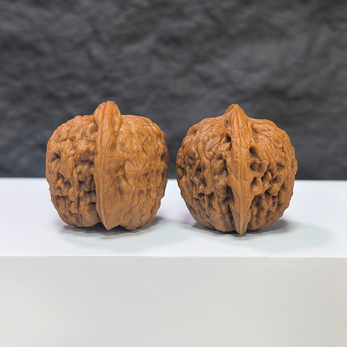 Pair of miniature Wenwan Walnuts featuring pocket meteorite Sycee carvings, crafted by Wenwan Art, measuring approximately 30mm by 31mm.