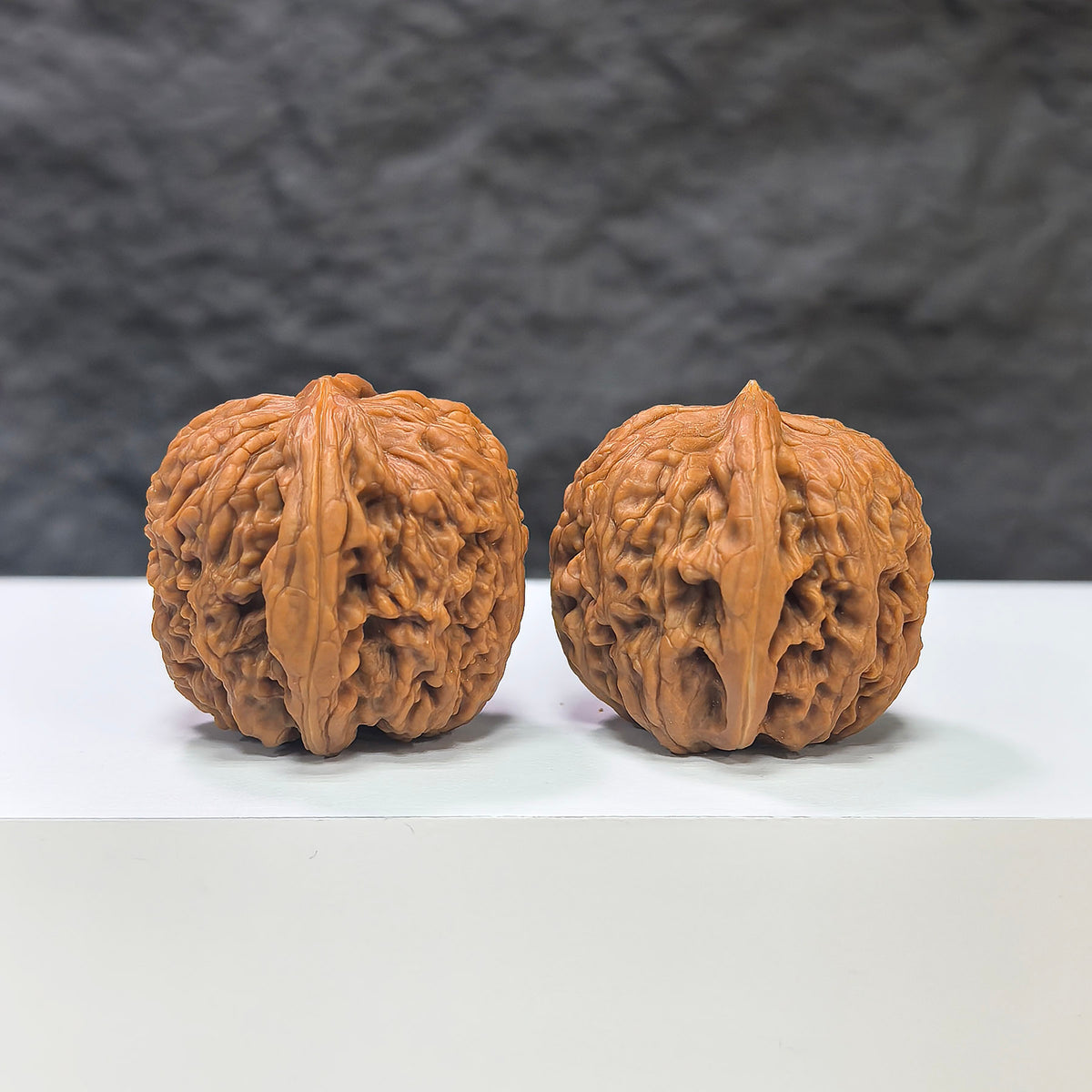 Pair of Nuwa Stone Wenwan walnuts from Wenwan Art, 38mm x 37mm, showcasing natural stone texture and craftsmanship.