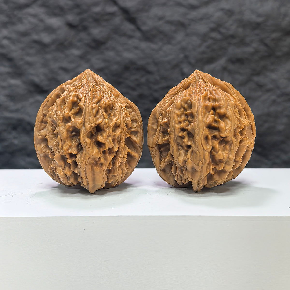 Pair of Dazhan Stone Wenwan walnuts from Wenwan Art, 43mm x 45mm, showcasing polished, natural stone textures and craftsmanship.
