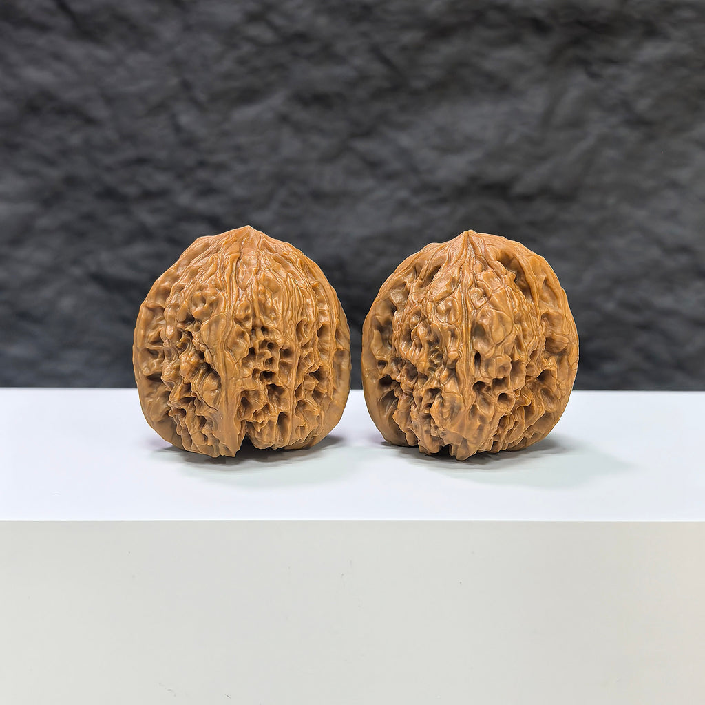 Pair of Nanjiangstone Wenwan walnuts by Wenwan Art, 36mm x 34mm, showcasing detailed natural stone textures and craftsmanship.