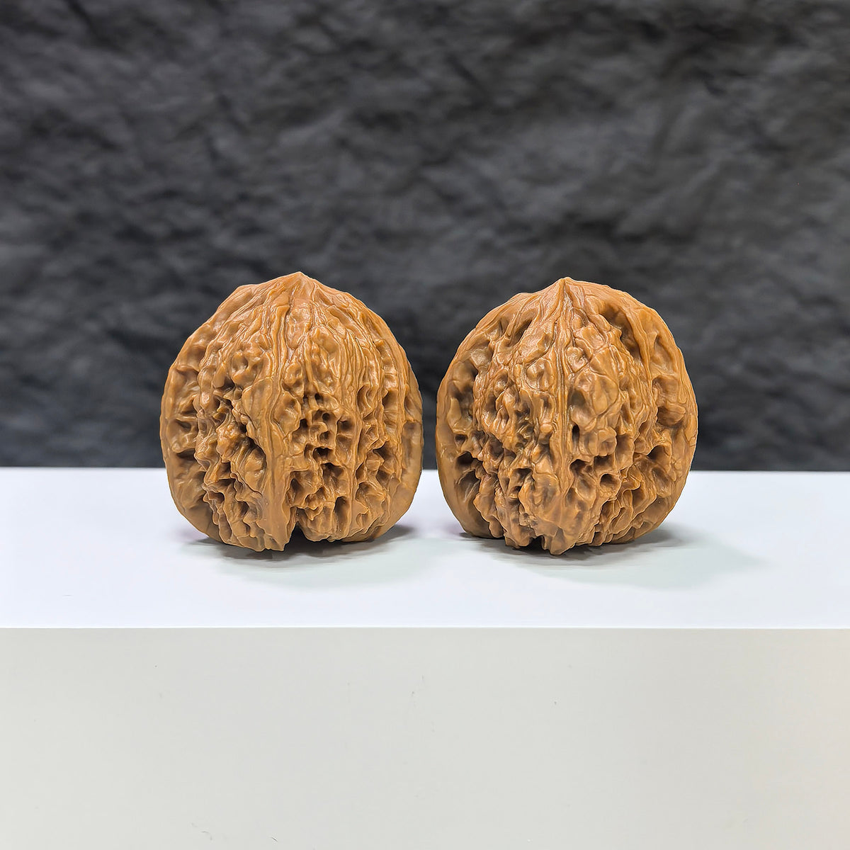 Pair of Nanjiangstone Wenwan walnuts by Wenwan Art, 36mm x 34mm, showcasing detailed natural stone textures and craftsmanship.