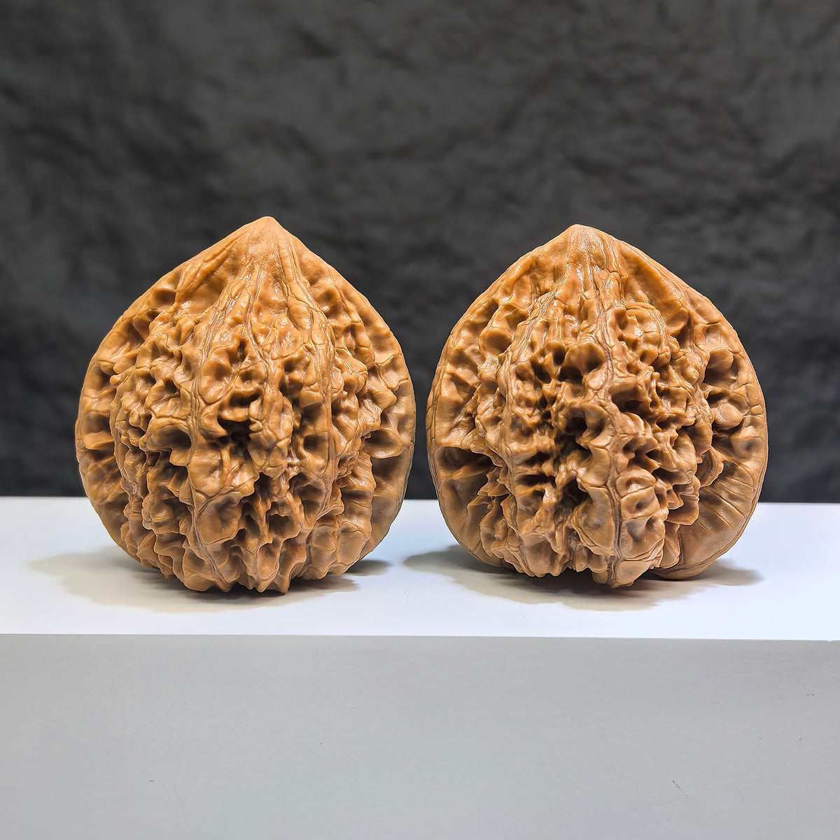 Pair of Wenwan Art Classic Scholar hand-matched Wenwan walnuts with peach heart and qilin patterns, 47mm x 43mm.