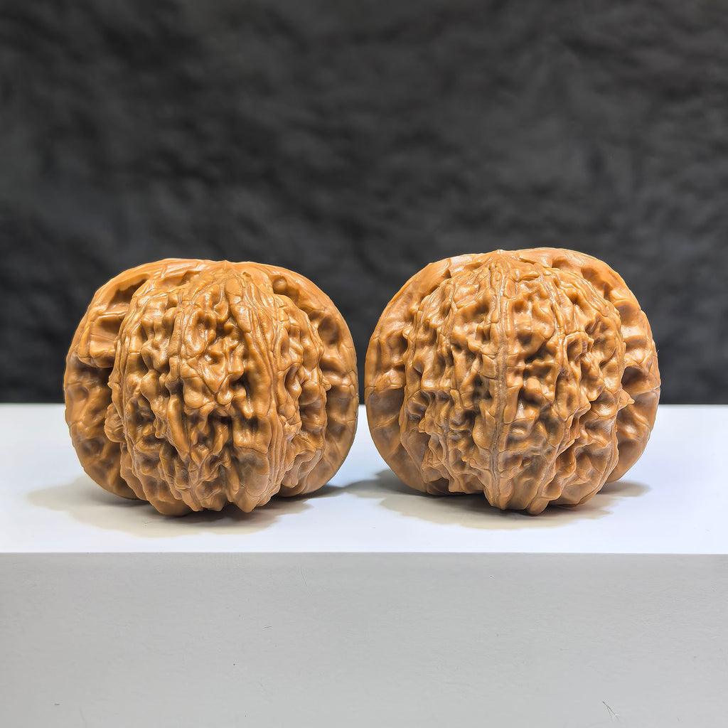 Pair of spherical white lion Wenwan walnuts from Wenwan Art, round-profile, 44mm x 43mm, detailed carved white walnut sculptures.