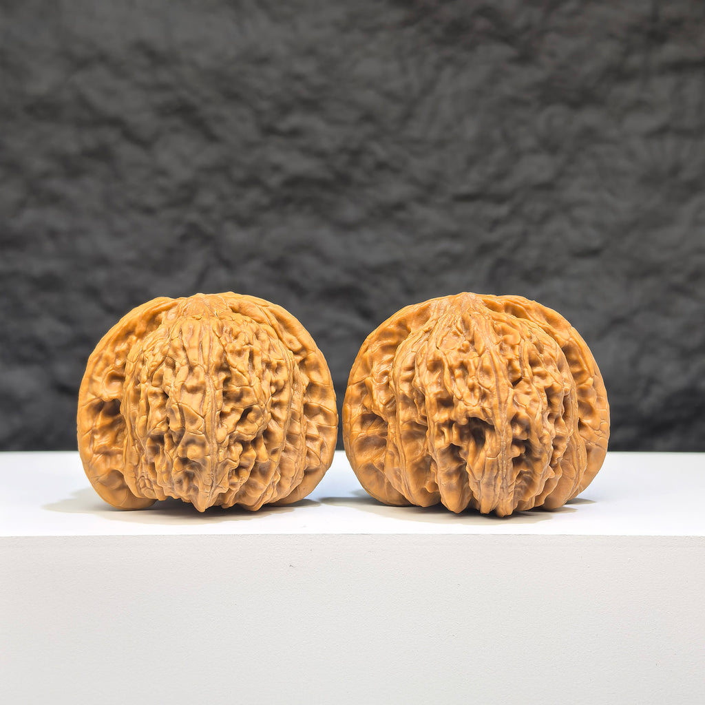 Pair of Wenwan Art "Ruby" classic Wenwan walnuts, 41mm x 37mm, featuring red gemstone-like appearance and detailed craftsmanship.