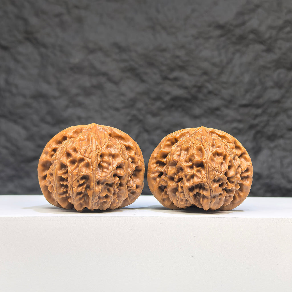 Pair of Palace Lantern Wenwan walnuts from Wenwan Art, featuring detailed carvings and a smooth, polished surface, 41mm by 37mm.