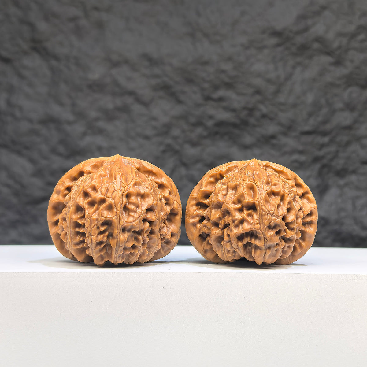 Pair of Palace Lantern Wenwan walnuts from Wenwan Art, featuring detailed carvings and a smooth, polished surface, 41mm by 37mm.