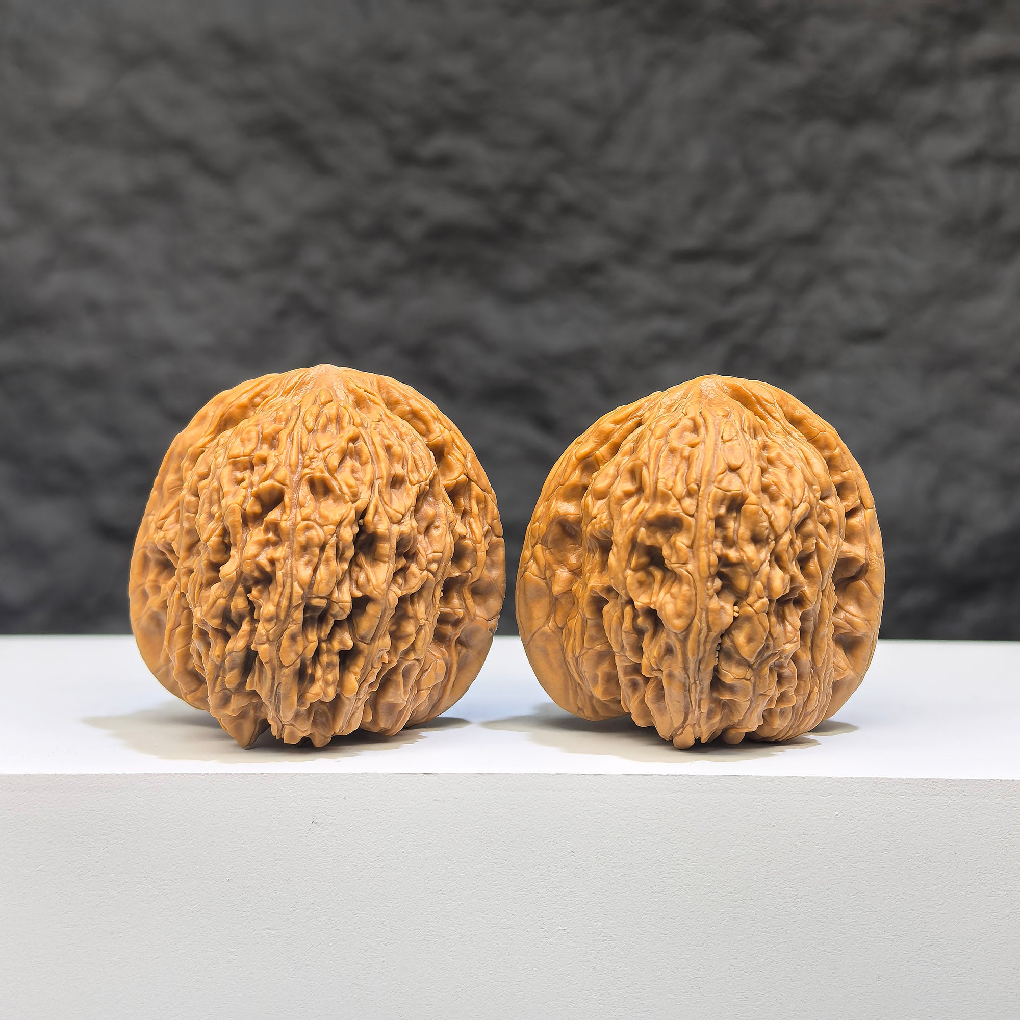 Pair of Wenwan Art "Ruby" classic Wenwan walnuts, 36mm, featuring rich red gemstone-like appearance and detailed carved patterns.
