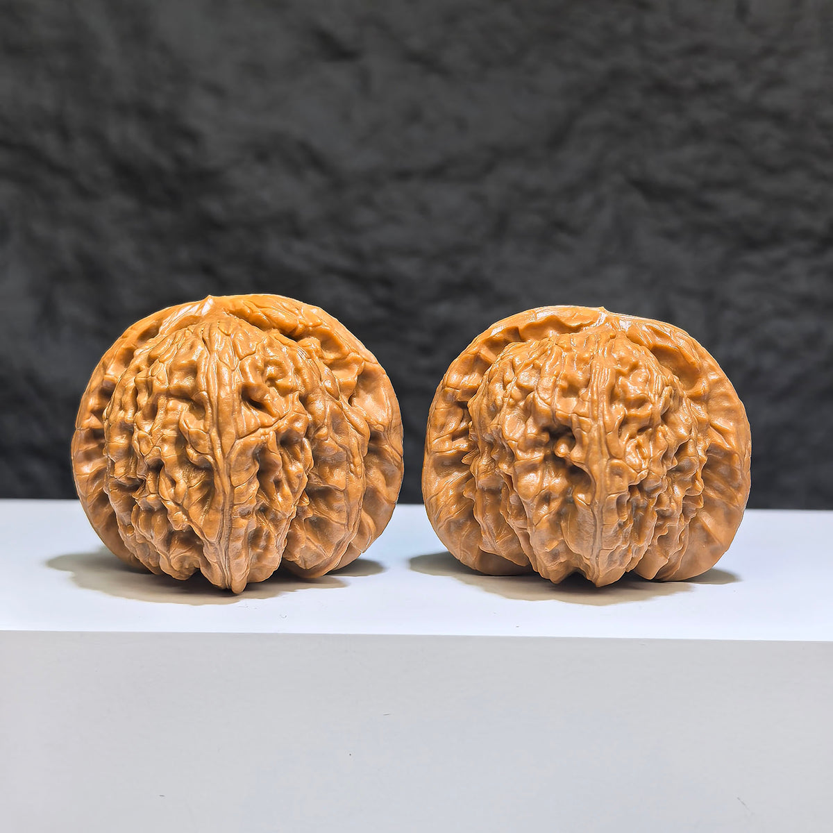 Pair of spherical white lion Wenwan walnuts from Wenwan Art, round profile, 43mm and 40mm, detailed white lion carvings.