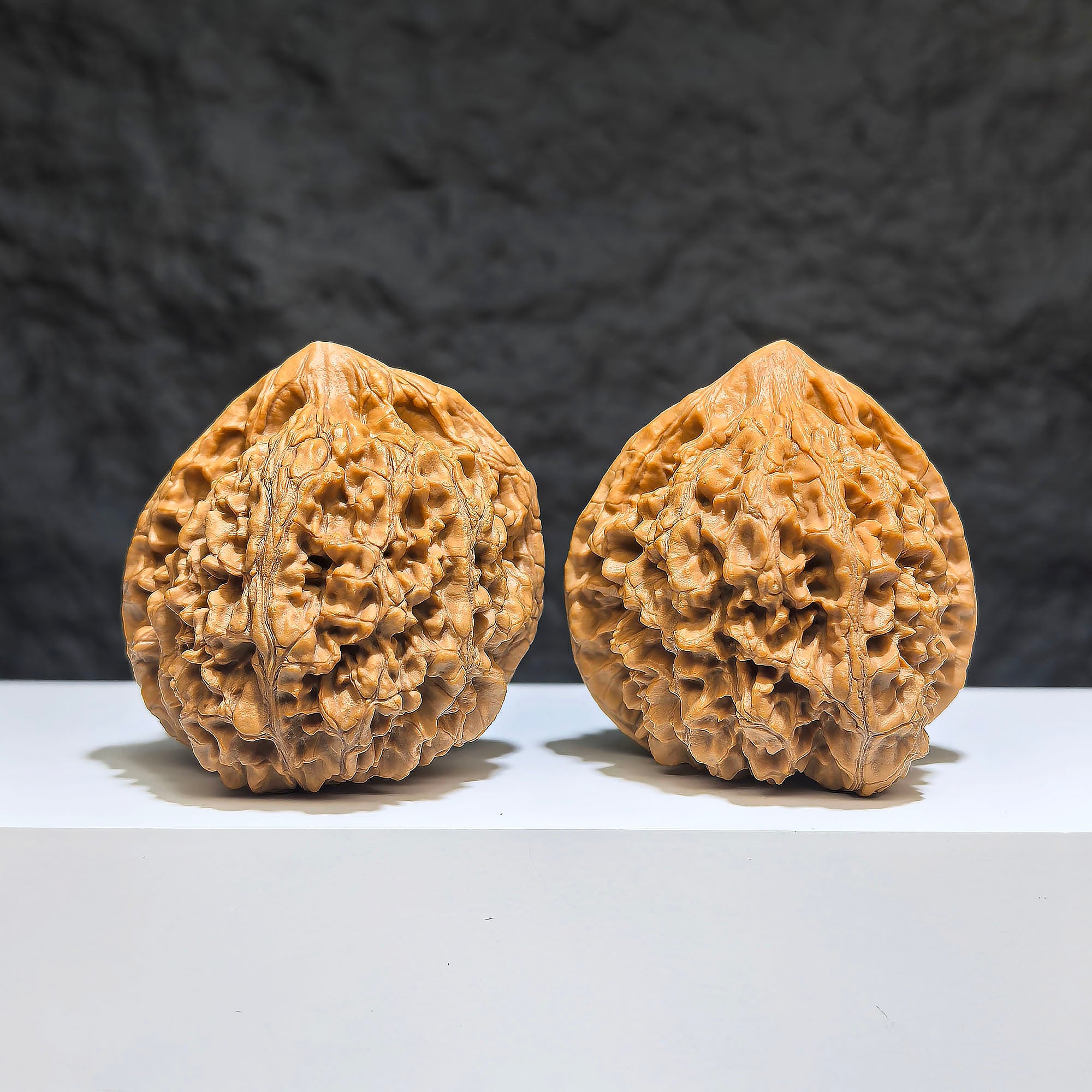 Pair of large Wenwan Art official hat-shaped walnuts, 49mm x 46mm, featuring smooth, polished surfaces with intricate natural patterns.