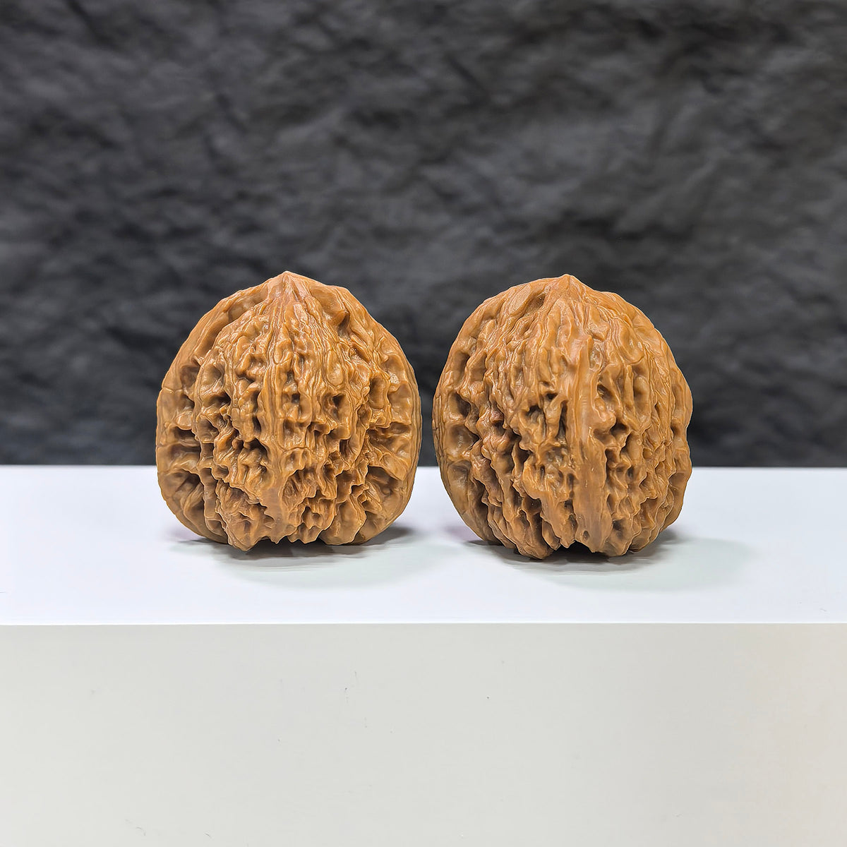 Pair of Nanjiangstone Wenwan walnuts by Wenwan Art, showcasing smooth, rounded walnut shapes with natural stone patterns.