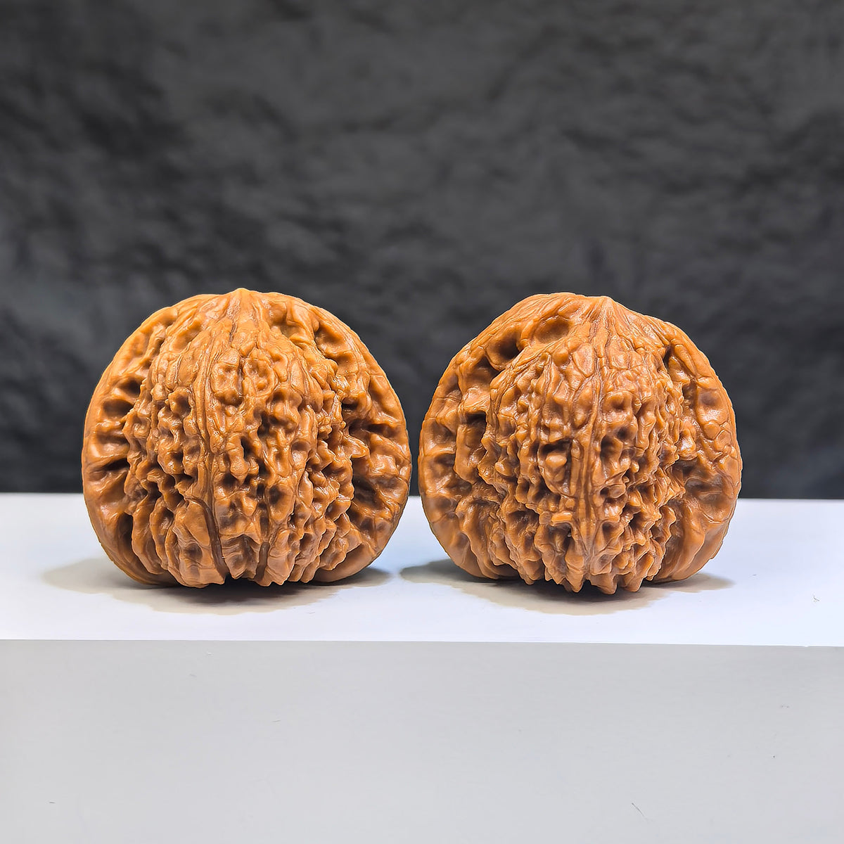 Pair of red shell Nanjiangstone Wenwan walnuts from Wenwan Art, 40mm x 38mm, showcasing intricate natural patterns and smooth finish.