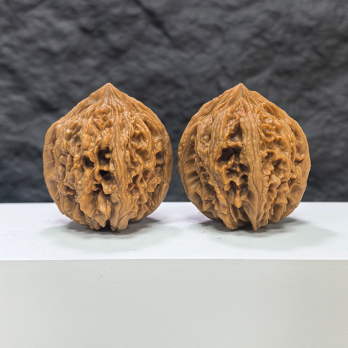 Pair of Dazhan Stone Wenwan walnuts by Wenwan Art, 43mm x 45mm, showcasing polished, natural stone textures and intricate details.