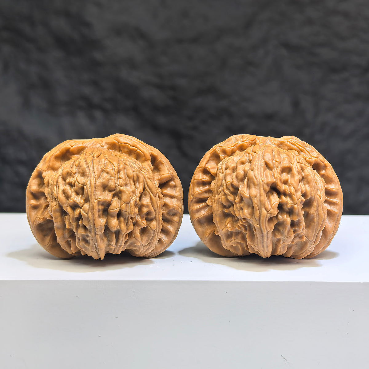 Pair of Low-pointed White Lion Wenwan Walnuts from Wenwan Art, 41mm x 38mm, featuring detailed carved white lion designs.
