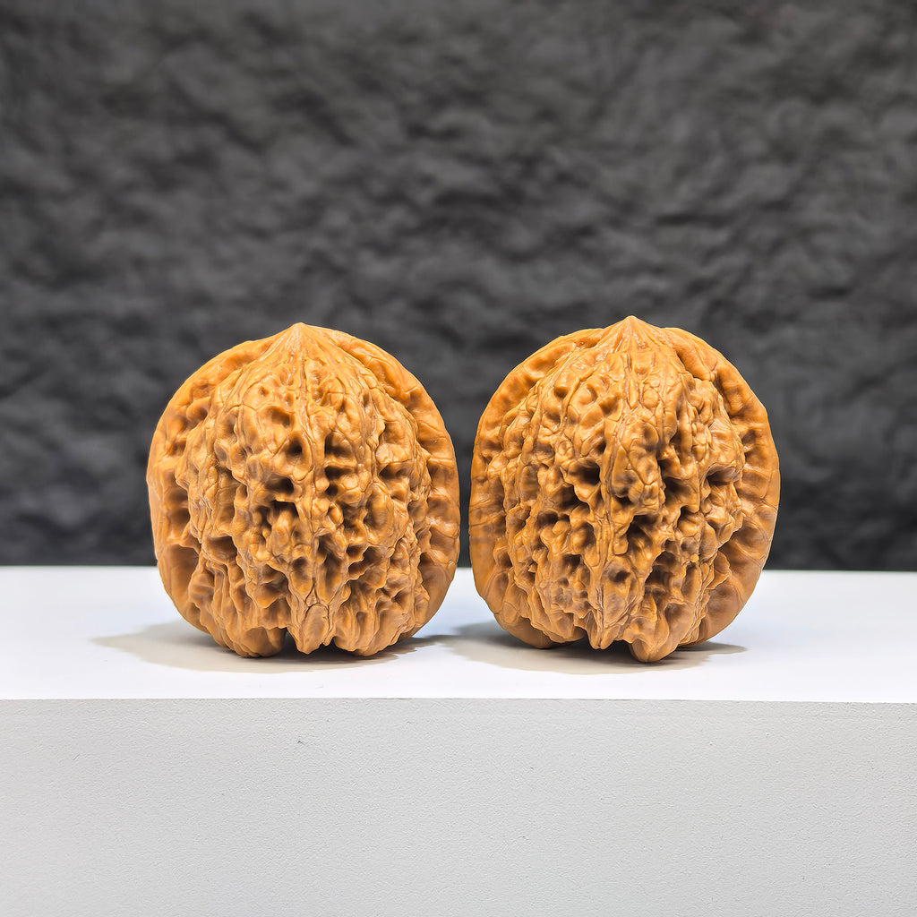 Pair of Wenwan Art Pocket Yuhua Stone miniature walnuts, 34mm x 32mm, showcasing detailed natural Wenwan walnut carvings.