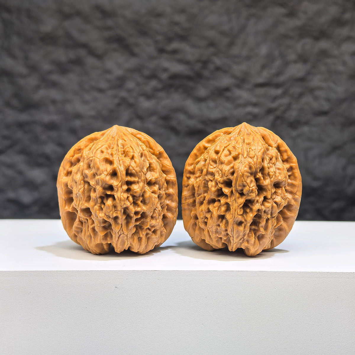 Pair of Wenwan Art Pocket Yuhua Stone miniature walnuts, 34mm x 32mm, showcasing detailed natural Wenwan walnut carvings.