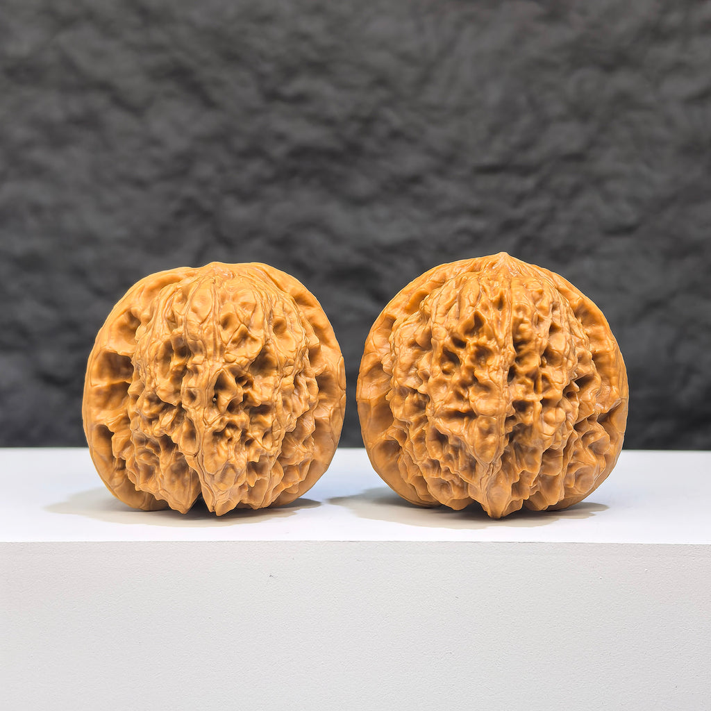 Pair of Yuhua Stone Wenwan walnuts from Wenwan Art, 37mm x 34mm, showcasing polished natural stone with intricate patterns.