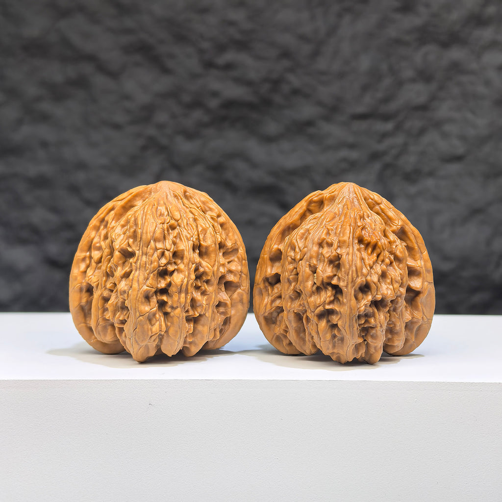 Pair of Yuhua Stone Wenwan walnuts by Wenwan Art, 36mm x 35mm, showcasing intricate natural stone textures and craftsmanship.