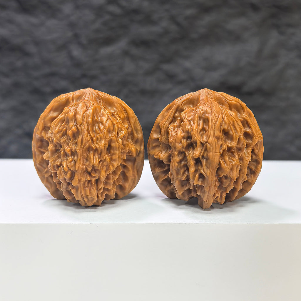 Pair of Wuling Mountain Pocket Wenwan walnuts from Wenwan Art, miniature 35mm x 32mm, showing intricate carvings and natural walnut texture.