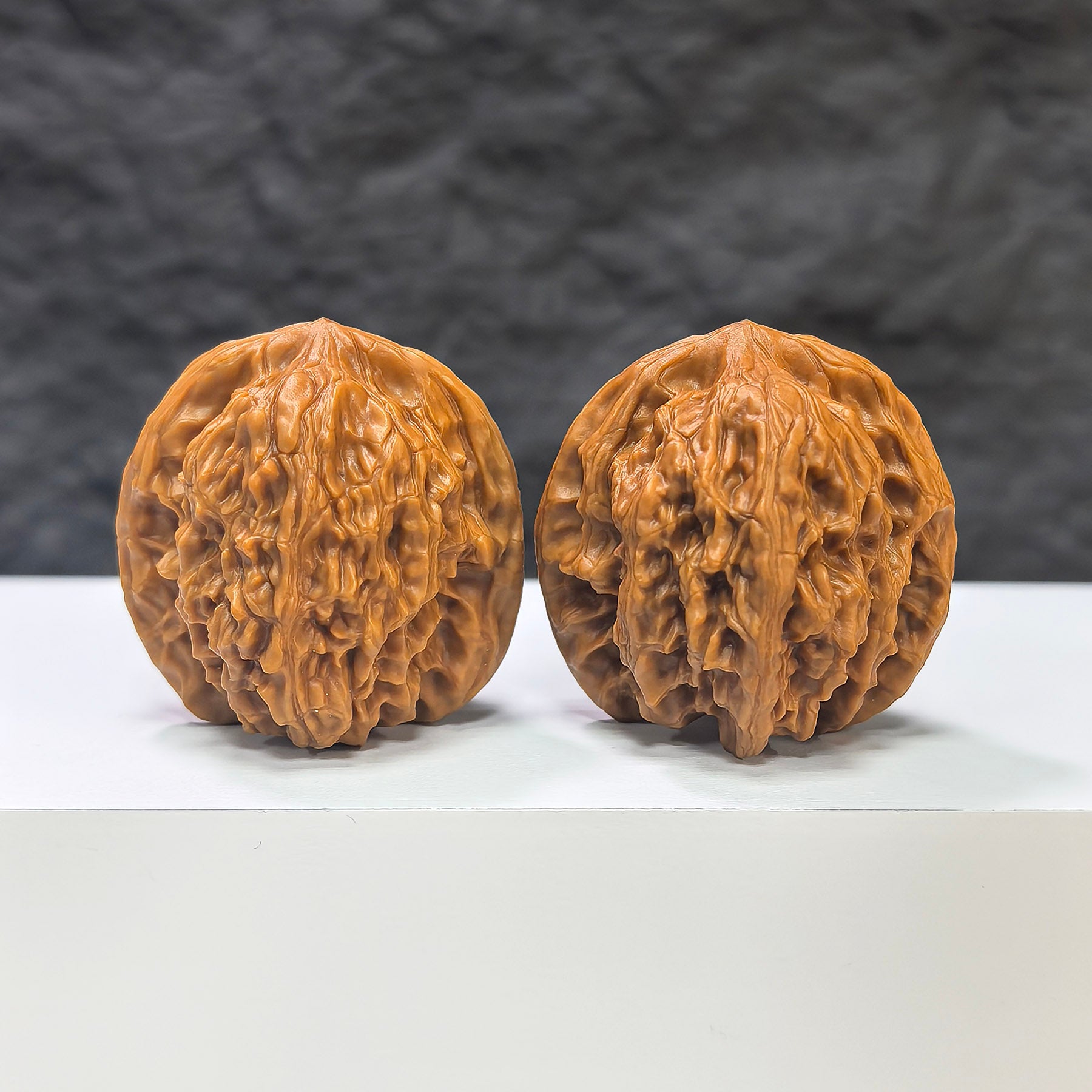Pair of Wuling Mountain Pocket Wenwan walnuts from Wenwan Art, miniature 35mm x 32mm, showing intricate carvings and natural walnut texture.