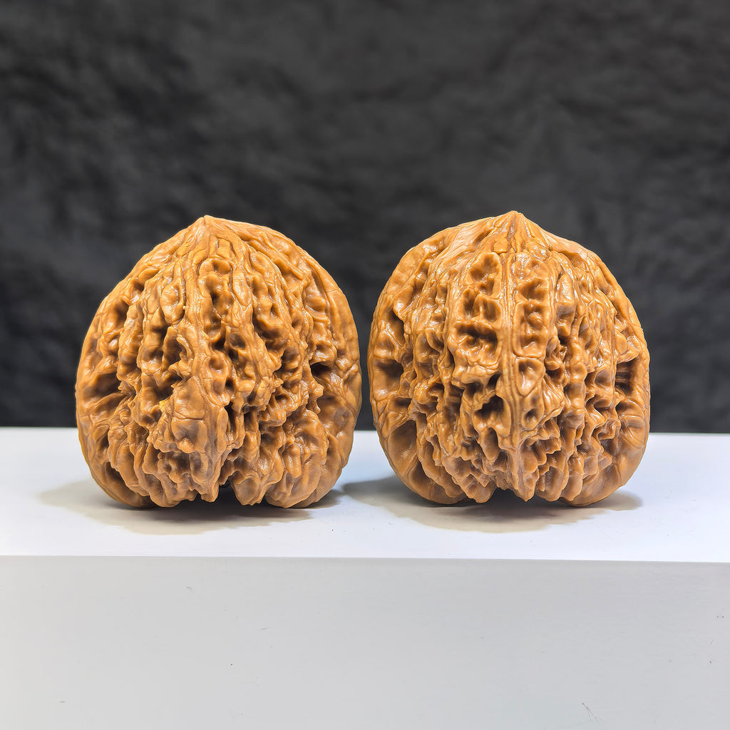 Pair of Nanjiangstone Wenwan walnuts by Wenwan Art, 41mm x 40mm, showcasing smooth, polished walnut carvings with natural stone texture.