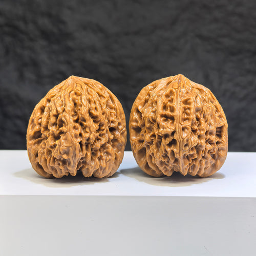 Pair of Nanjiangstone Wenwan walnuts by Wenwan Art, 41mm x 40mm, showcasing smooth, polished walnut carvings with natural stone texture.