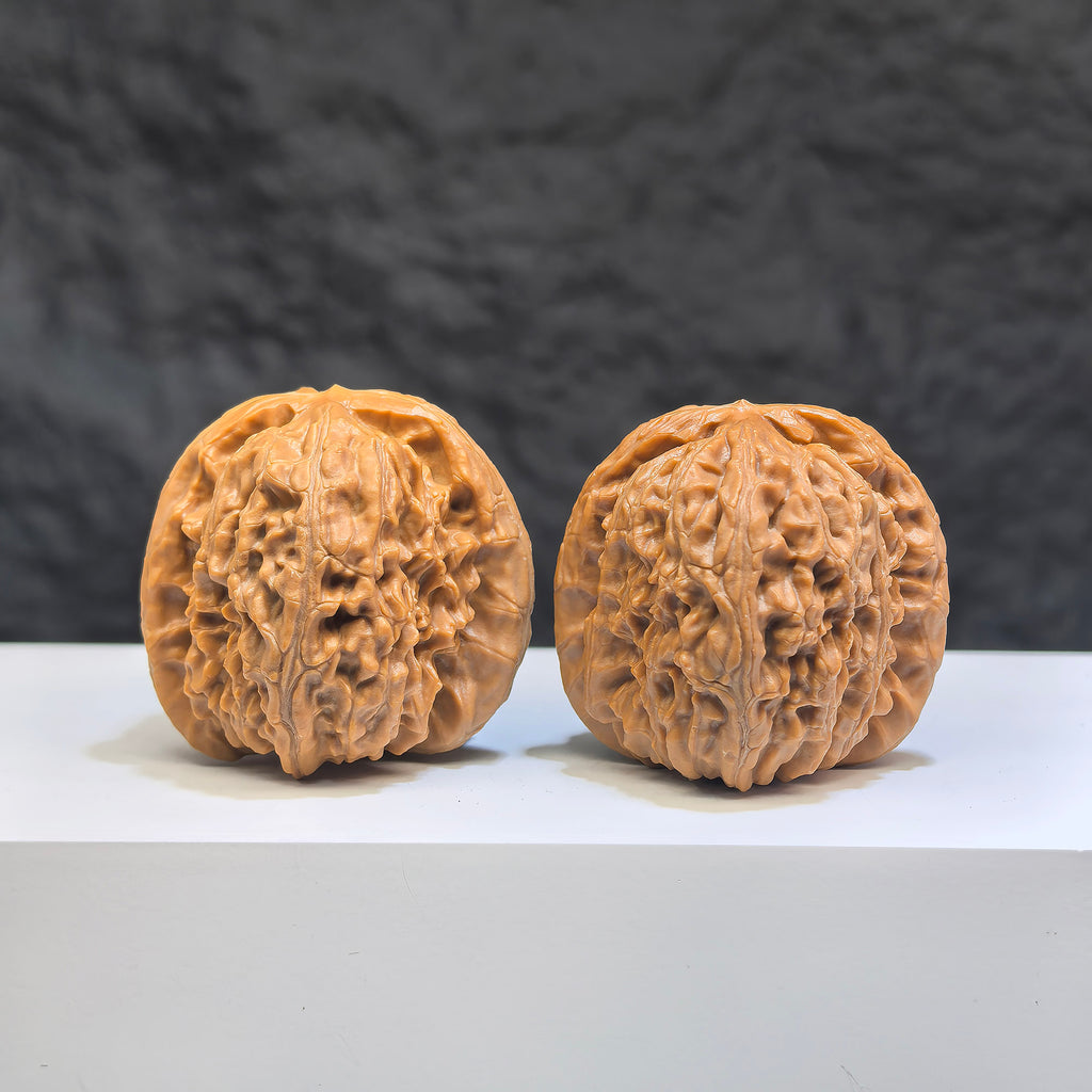 Pair of White Lion Wenwan Walnuts from Wenwan Art, 36mm, featuring detailed carvings of lion heads on smooth polished walnut surfaces.