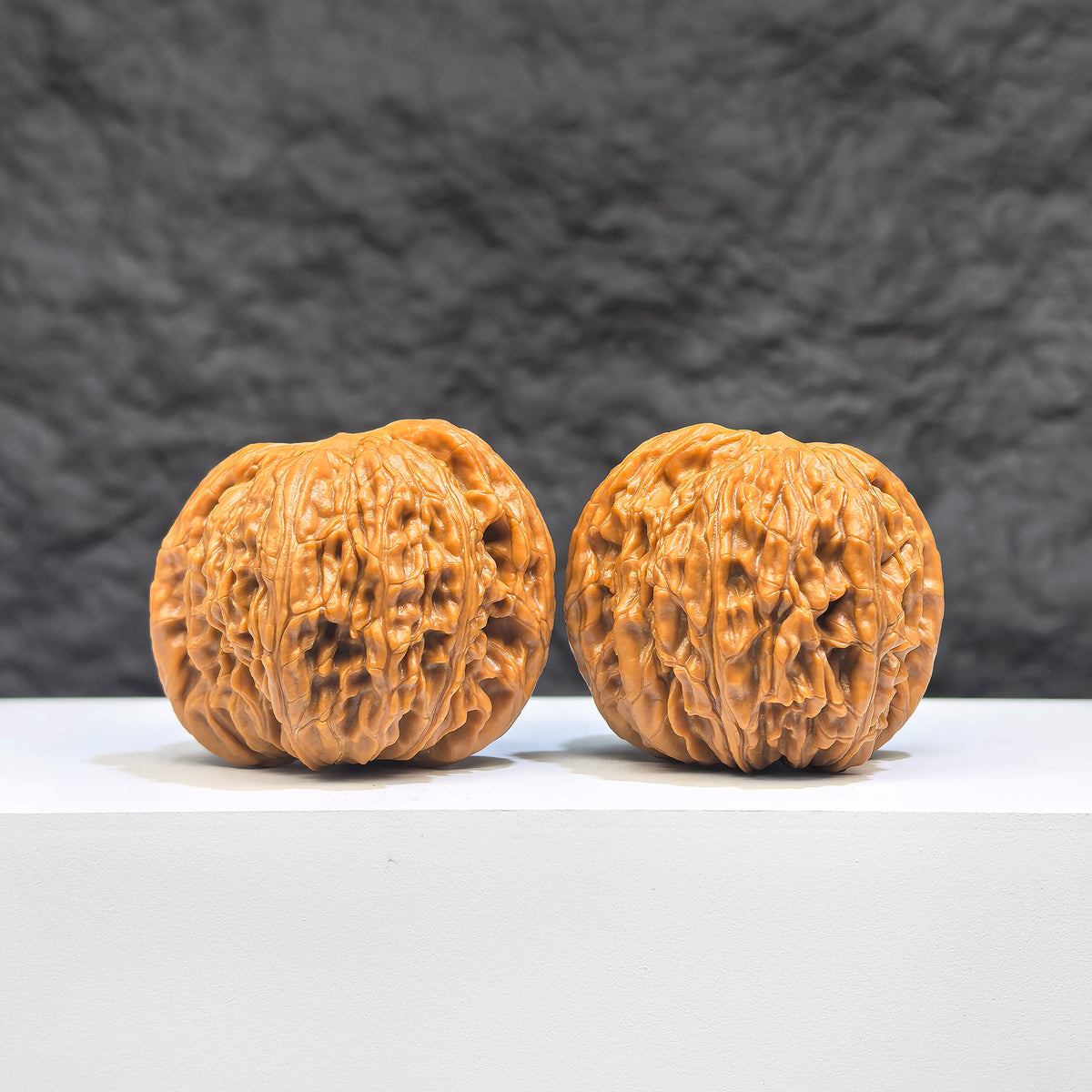 Pair of Wenwan Art Millstone Classic Wenwan Walnuts, featuring detailed carved patterns, measuring 37mm by 35mm.