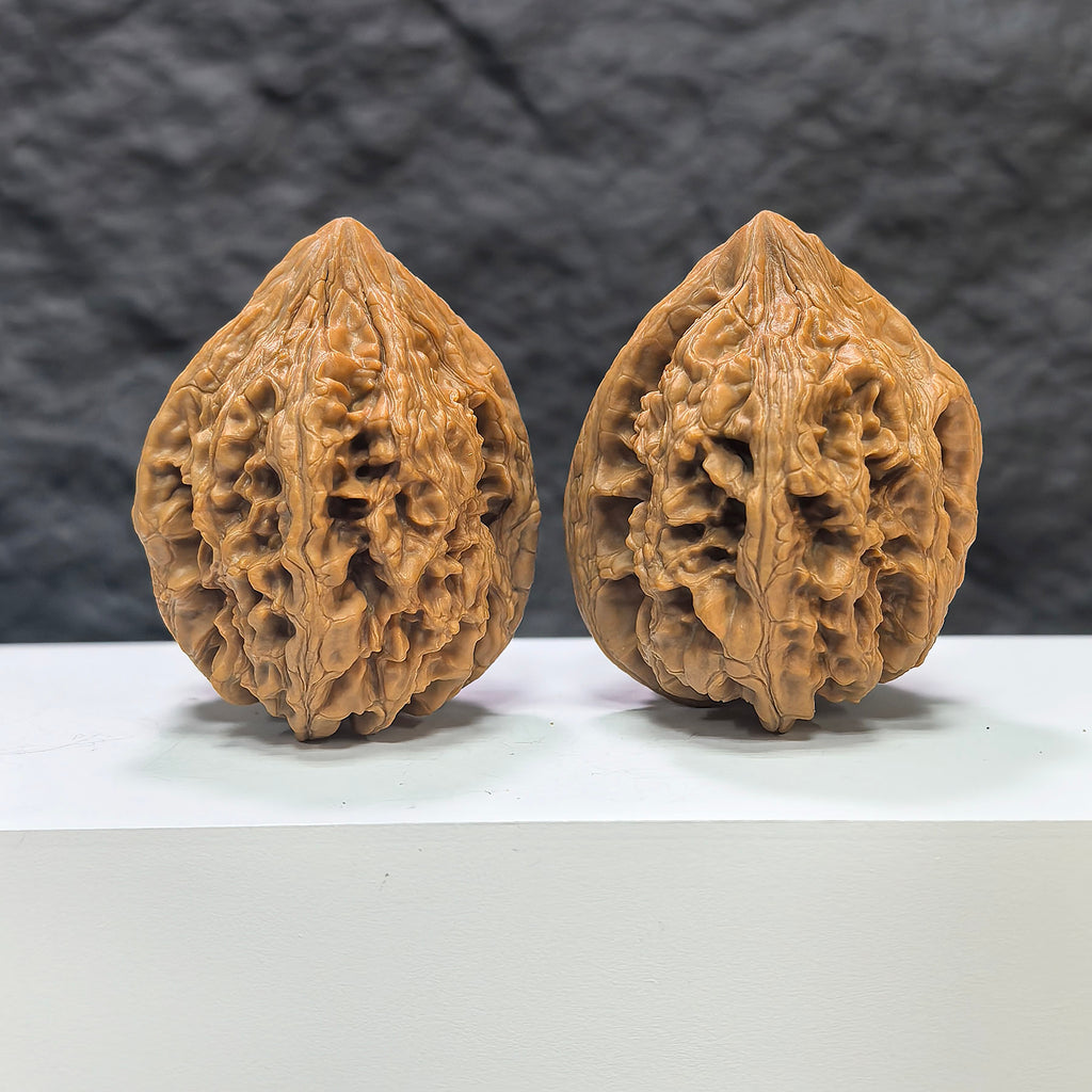 Pair of Dazhan Stone Wenwan walnuts by Wenwan Art, classic 42mm x 46mm natural stone walnuts with intricate carvings.