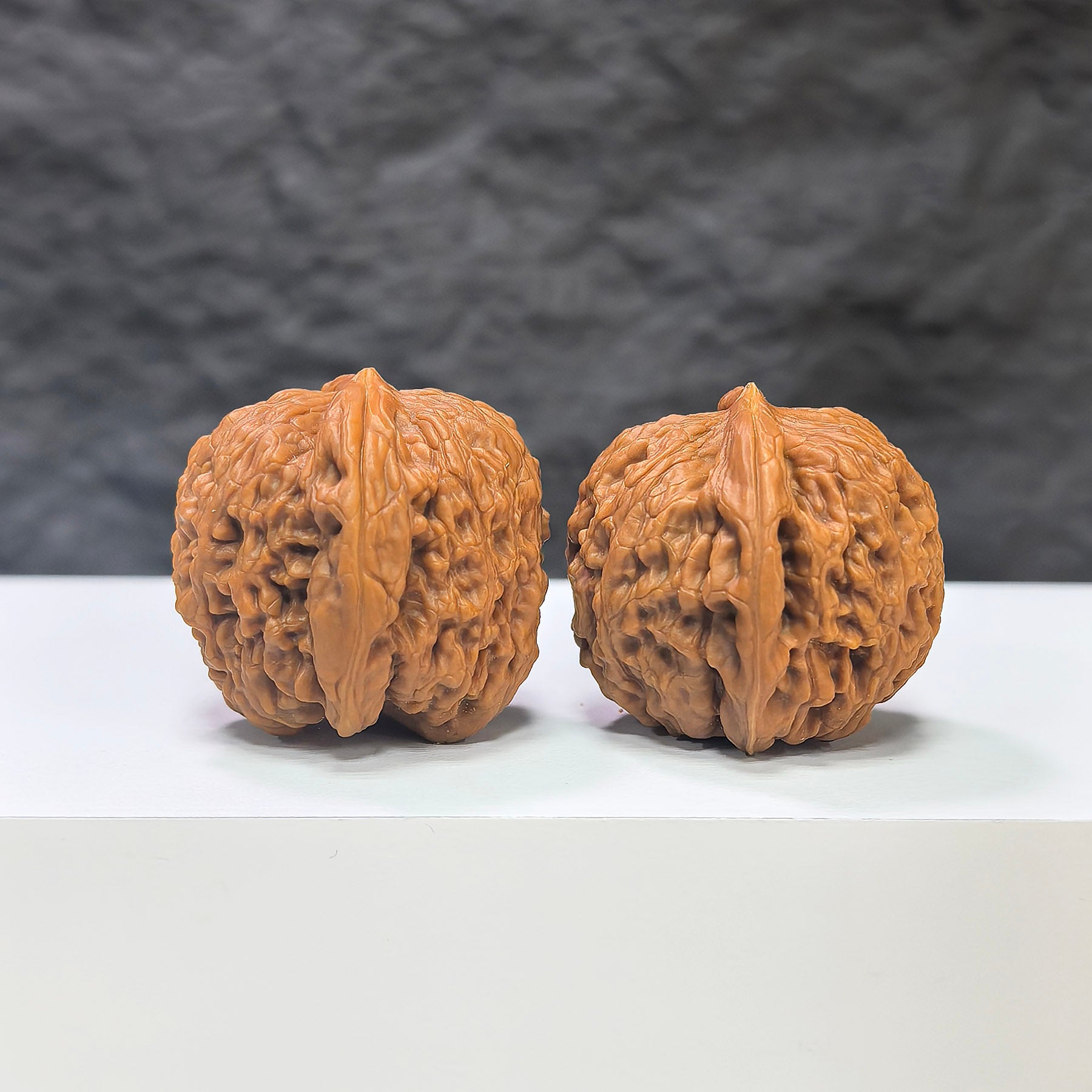 Pair of Nuwa Stone Wenwan walnuts from Wenwan Art, measuring 38mm x 37mm, showcasing polished natural stone surfaces.