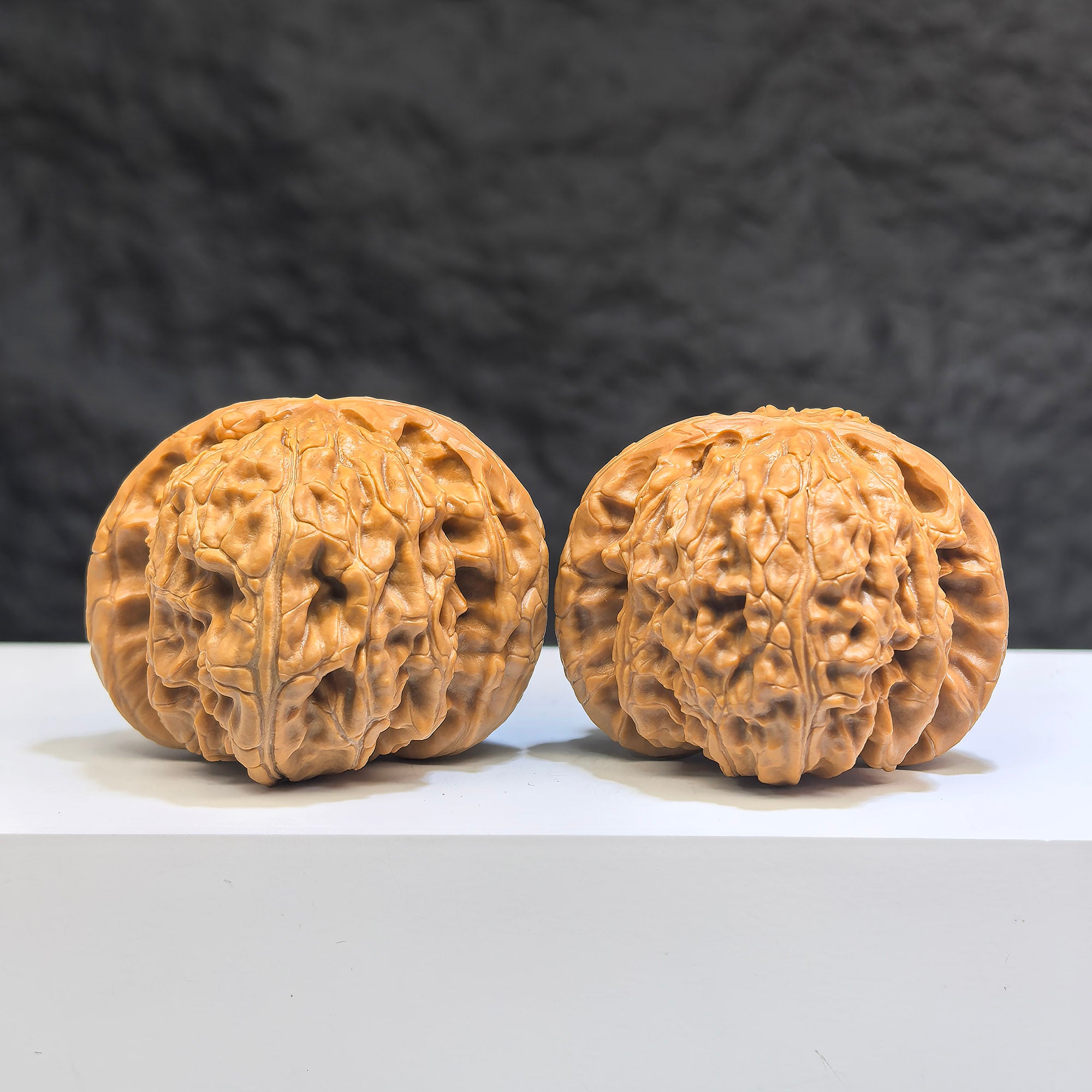 Pair of White Lion Wenwan walnuts from Wenwan Art, 42mm x 41mm, featuring detailed carved white lion designs on smooth walnut surfaces.