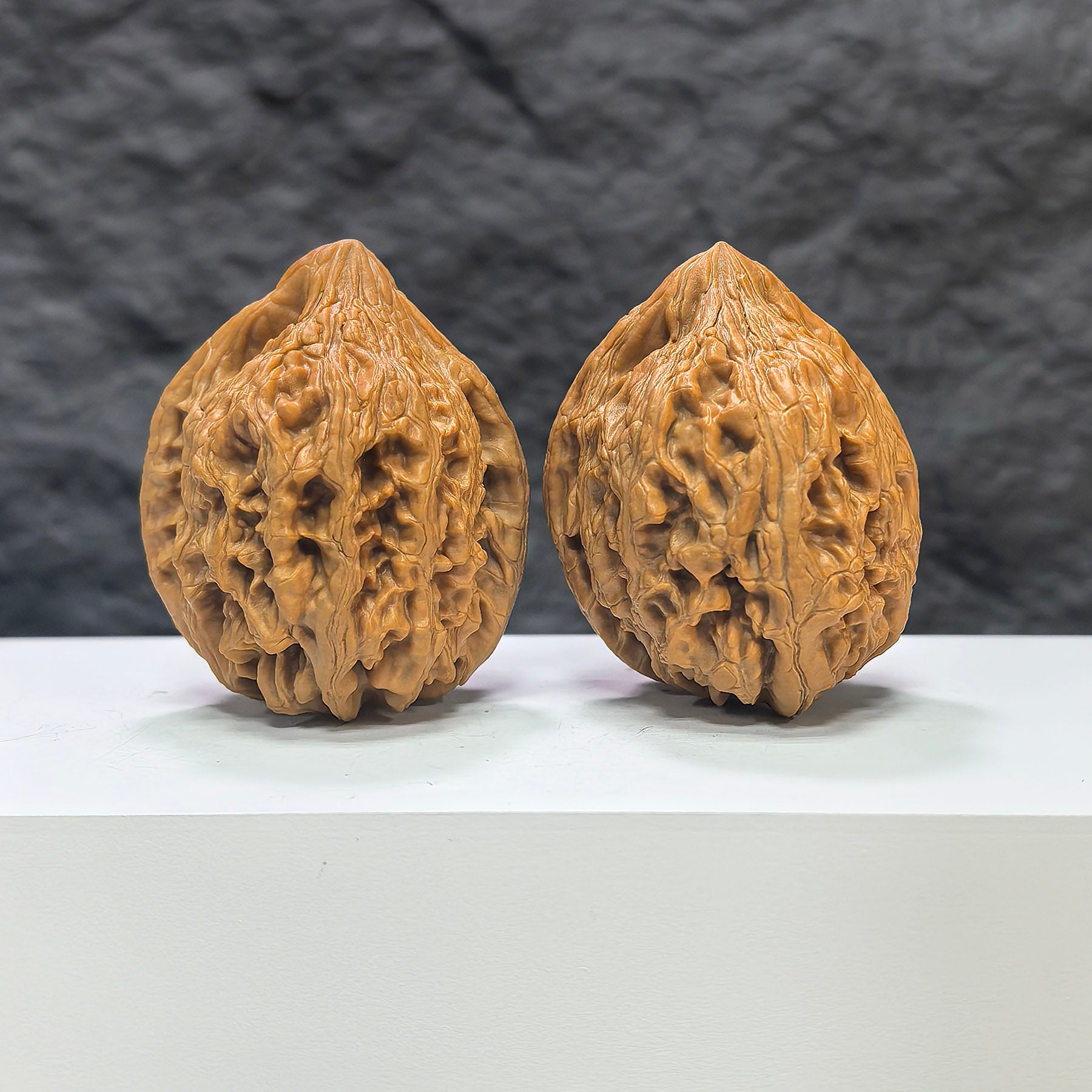 Pair of Dazhan Stone Wenwan walnuts from Wenwan Art, 41mm x 42mm, showcasing natural stone patterns and smooth polished surfaces.