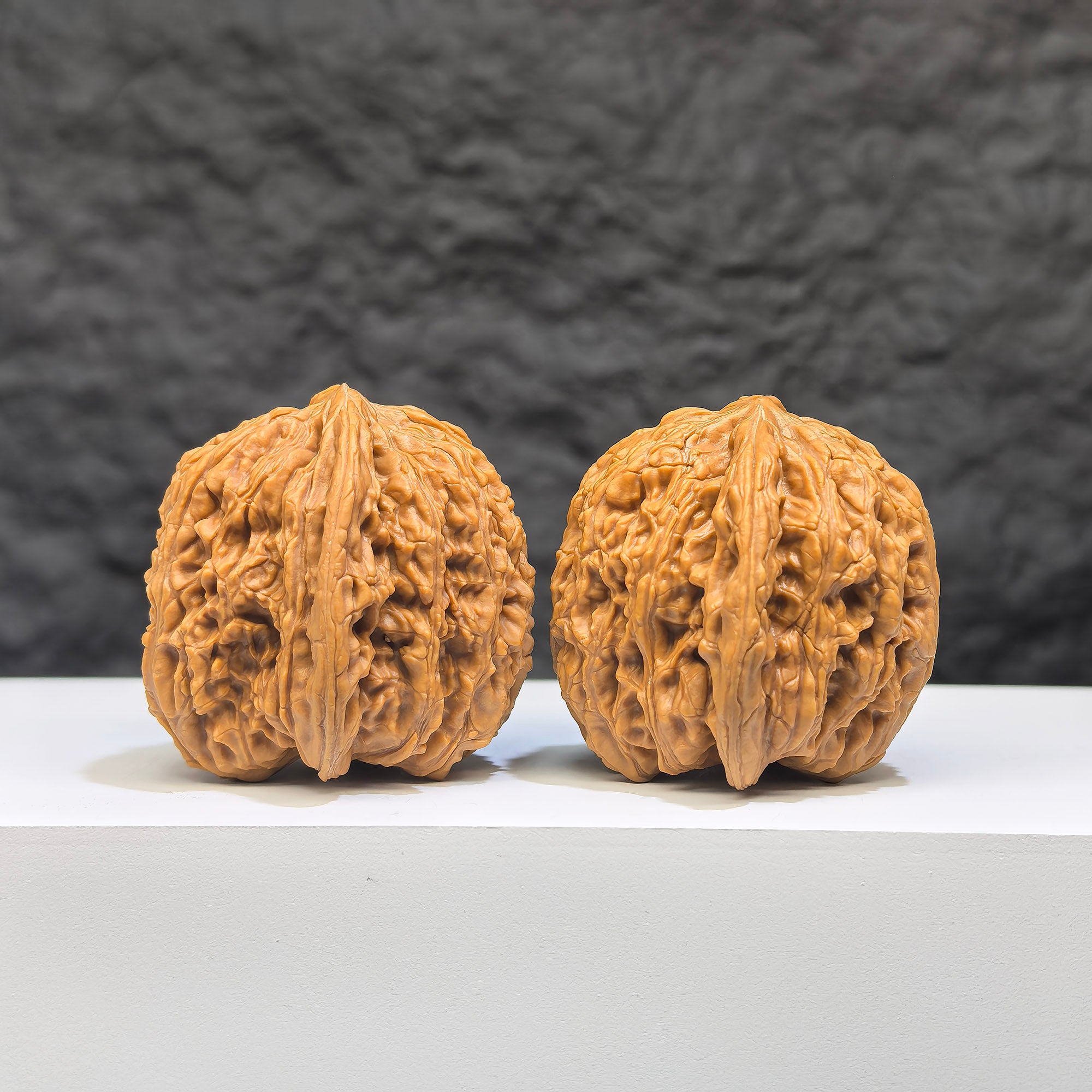 Pair of Wenwan Art "Ruby" classic Wenwan walnuts, 36mm, with rich red gemstone appearance, showcasing intricate carvings and polished surfaces.