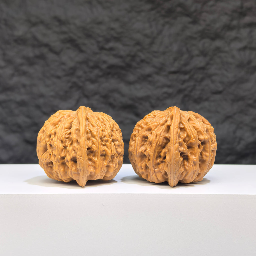 Pair of Wenwan Art "Ruby" classic Wenwan walnuts, 41mm x 37mm, featuring rich red gemstone-like appearance and intricate carvings.