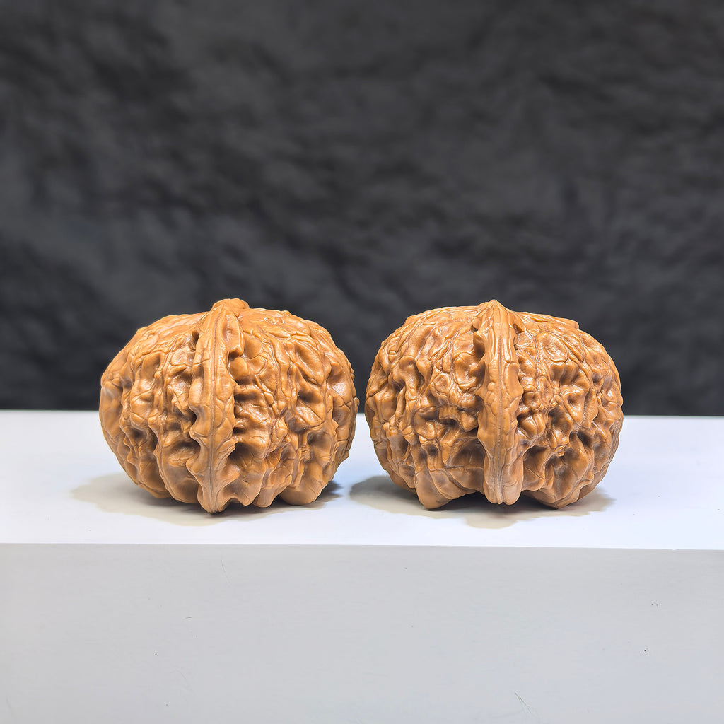 Pair of Pocket Spherical White Lion Wenwan Walnuts by Wenwan Art, 35mm round-profile decorative walnut carvings with lion design.