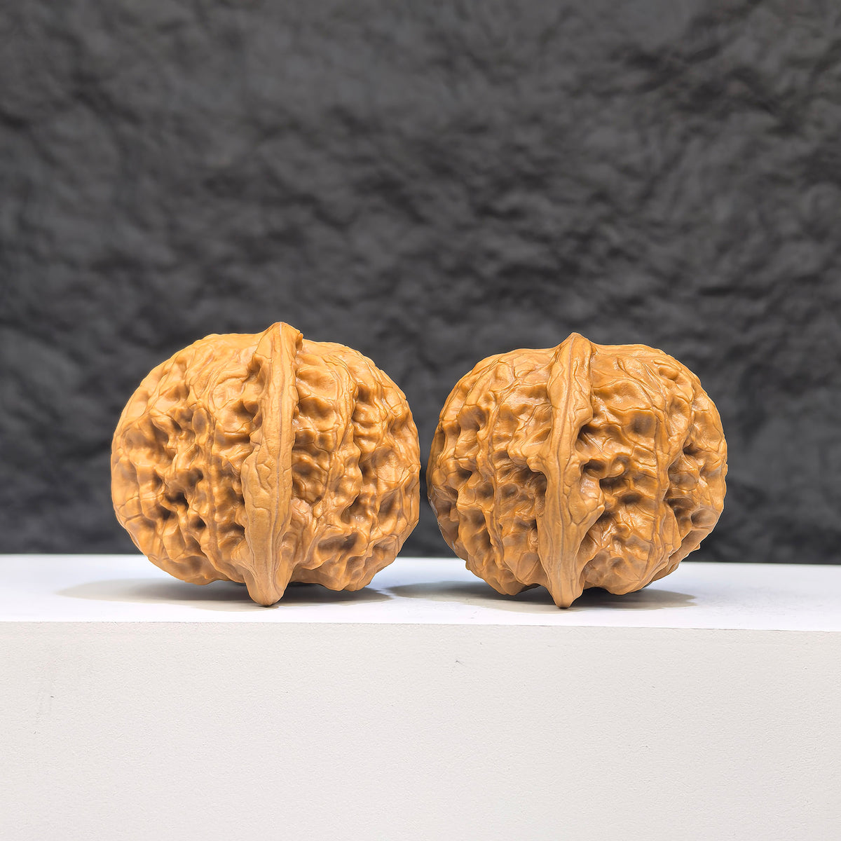 Close-up of two authentic Wenwan Wild Wolf walnuts from Wenwan Art, showcasing natural wood grain and unique walnut shapes.