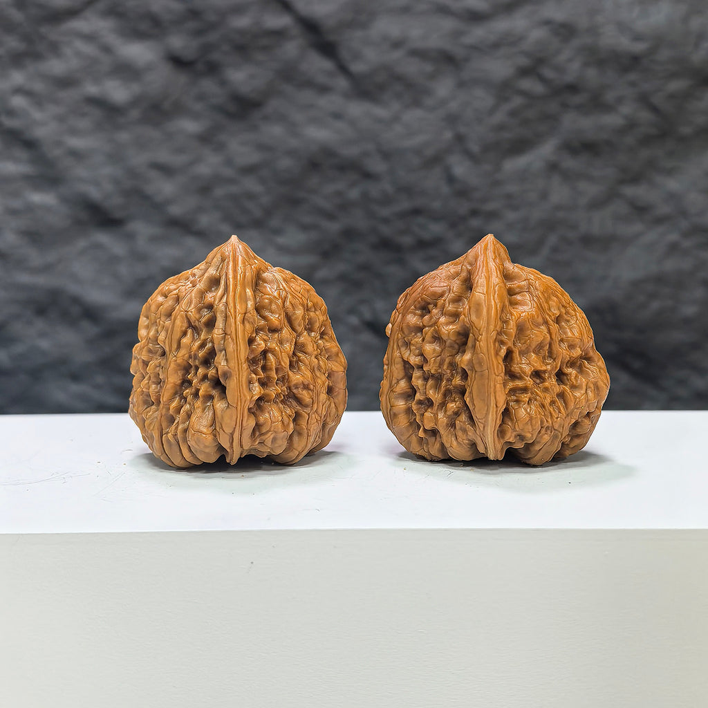 Pair of Pinggu Concave Base Wenwan walnuts from Wenwan Art, deep-base walnuts measuring 33mm by 37mm with smooth, polished surfaces.