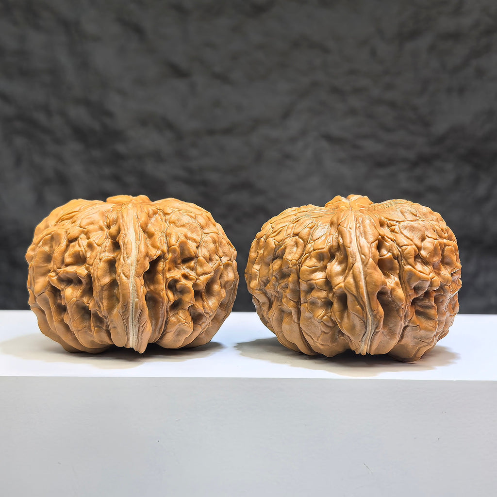 Pair of Huakun Dragon Wenwan walnuts from Wenwan Art, 49mm x 51mm, featuring intricate dragon-scale carvings.