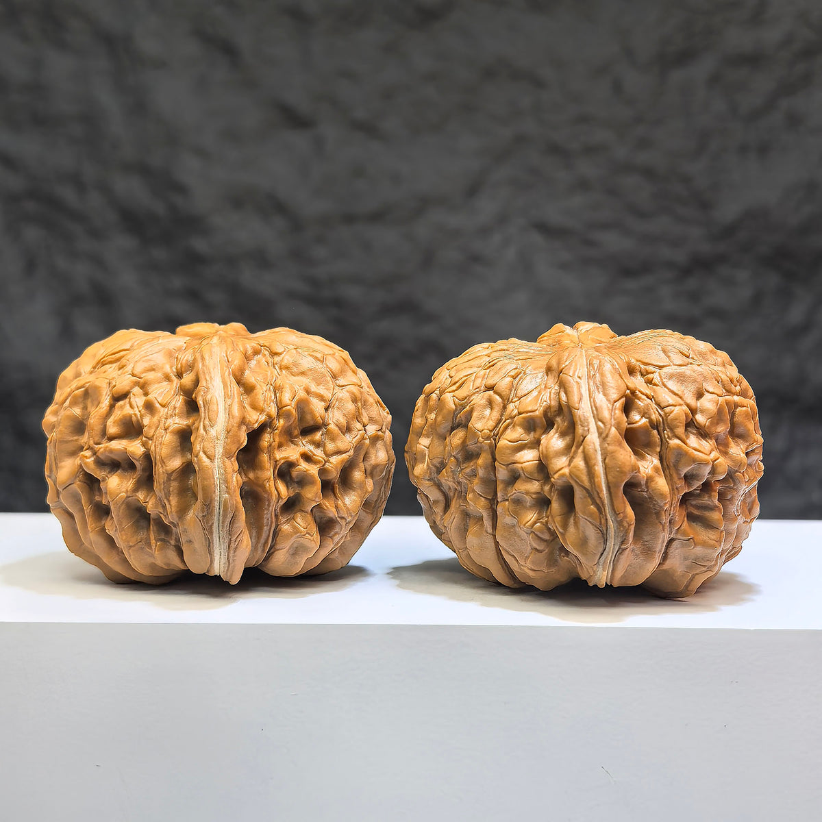 Pair of Huakun Dragon Wenwan walnuts from Wenwan Art, 49mm x 51mm, featuring intricate dragon-scale carvings.