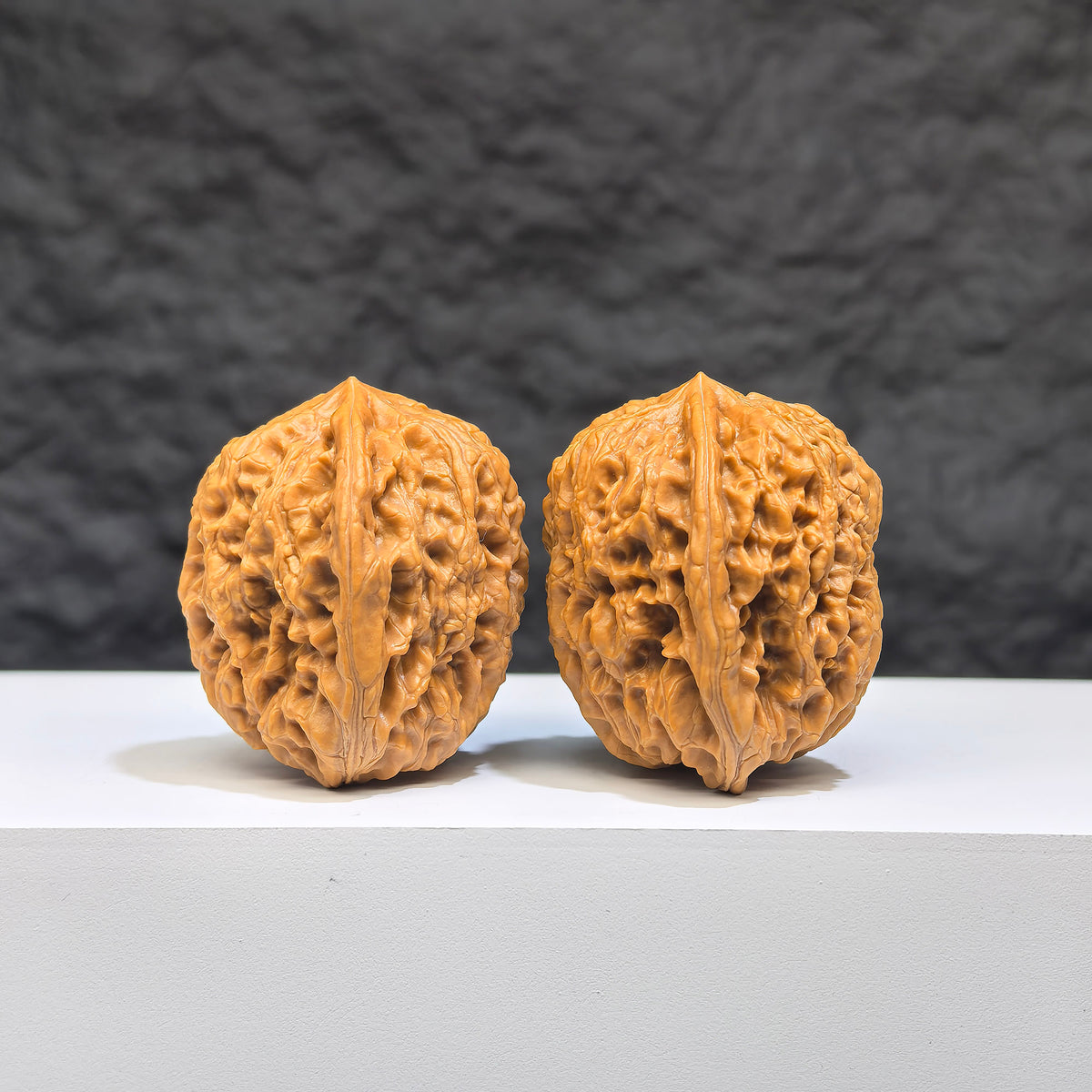 Pair of miniature Wenwan Yuhua Stone walnuts from Wenwan Art, 34mm x 32mm, featuring detailed natural stone carvings.
