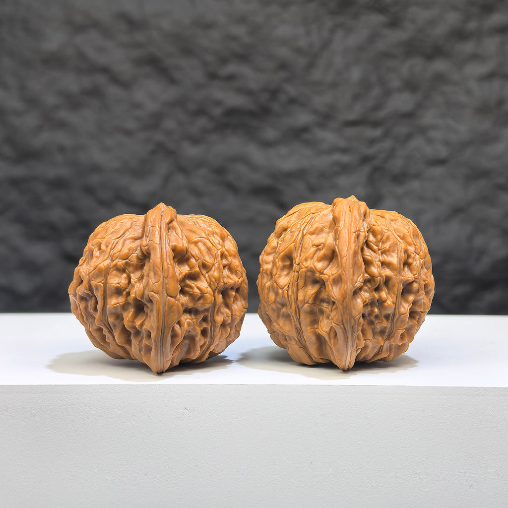 Pair of Wenwan Art Millstone Classic Wenwan walnuts, 38mm x 34mm, featuring detailed carved designs on smooth, polished surfaces.