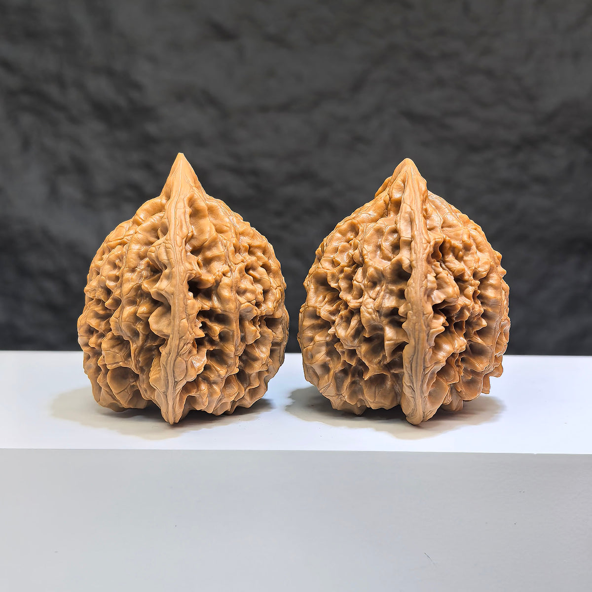 Hand-matched Wenwan Scholar walnuts by Wenwan Art, featuring peach-heart carved design, 47mm x 43mm, with qilin pattern.