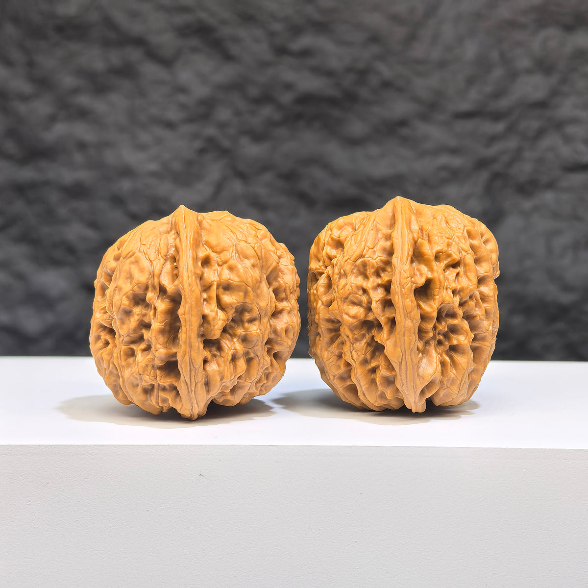 Pair of Wenwan Art Pocket Yuhua Stones, miniature walnut carvings with detailed natural textures, measuring 32mm each.